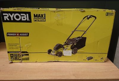un carton contenant une tondeuse à gazon posé sur une table en bois