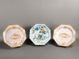 trois petites assiettes ornées d'oiseaux et de fleurs, posées sur une table