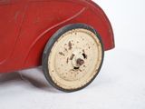 a red toy car that is sitting on a white surface