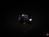 un diamant violet foncé sur une surface noire