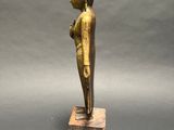 an image of a statue of a person standing on a wooden block