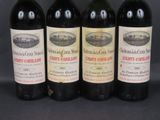 four bottles of wine are lined up on a black surface