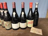 several bottles of wine are lined up on a wooden table