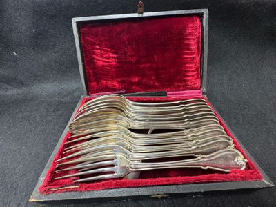 des couverts dans un coffret doublé de velours rouge sur un fond noir