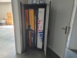 a bookcase with books on top of it in a garage