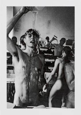 black and white photograph of a man standing in a room with a naked woman