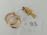 a close up of two gold rings and a tag on a white surface