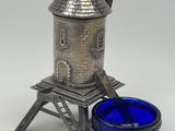 a silver and blue glass candle holder with a windmill on top of it