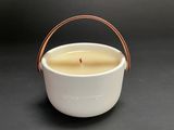 a close up of a candle in a white bowl on a table