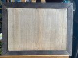 an easel with a painting on it sitting on top of a wooden easel