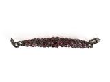 a close up of a bracelet with garnets on a white background