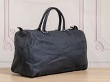 a black bag sitting on top of a wooden floor next to a wall