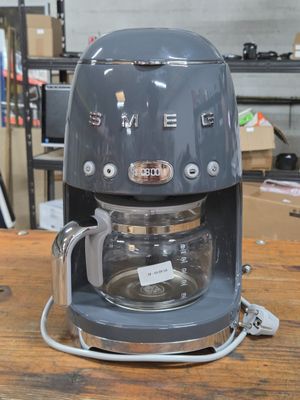a coffee maker sitting on a wooden table in a room