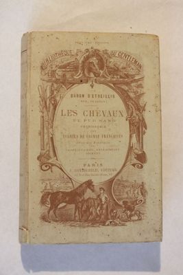 un vieux livre posé sur une table à côté d'une table blanche