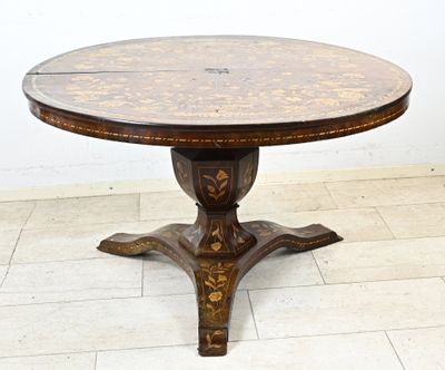 une table ronde avec un plateau en bois posée sur un sol carrelé