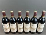 six bottles of wine lined up in a row on a table