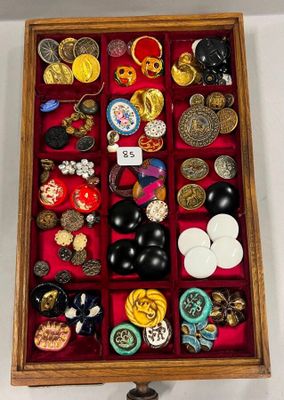 une boîte en bois remplie d'un assortiment de boutons et de broches