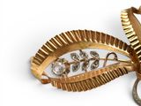 a gold brooch with a leaf design on it