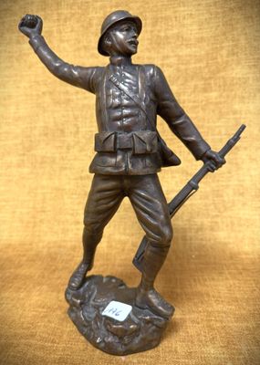 statue en bronze représentant un soldat tenant un fusil et pointant vers quelque chose