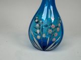 a blue glass vase with flowers painted on it