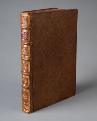 un livre en cuir marron avec des bordures dorées sur la couverture