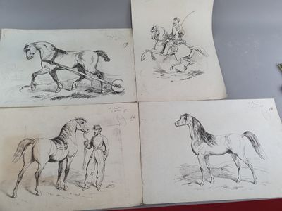 quatre dessins de chevaux sont posés sur une table, à côté d'une paire de ciseaux et d'une paire de ciseaux