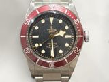 a close up of a wrist watch with a red bezel