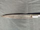 a knife with writing on it laying on a table