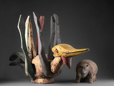 sculpture représentant un oiseau au long bec à côté d'un petit animal