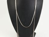 a close up of a necklace on a mannequin with a white background