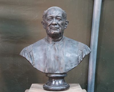 un buste d'homme assis sur un socle