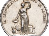 an image of a silver coin with a woman holding a jug
