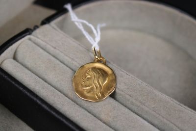 une pièce d'or représentant une femme, dans une boîte