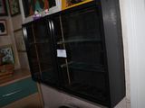 a refrigerator with glass doors in the corner of a room