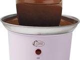 un gros plan d'une fontaine à chocolat dans un bol posé sur une surface blanche