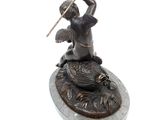 bronze statue of a woman with a spear and a bird on a rock