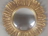 un miroir rond orné d'un motif à la feuille d'or