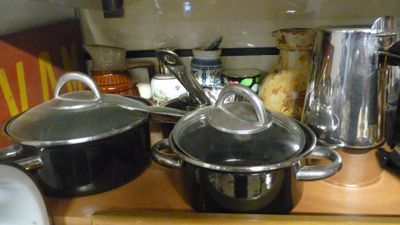 de nombreuses casseroles et poêles posées sur le plan de travail de la cuisine