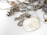 a pile of silver jewelry on a white surface