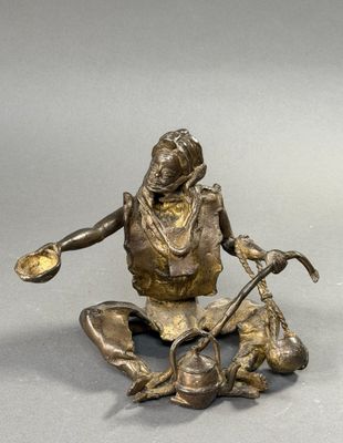 bronze statue of a woman sitting on the ground with a dog
