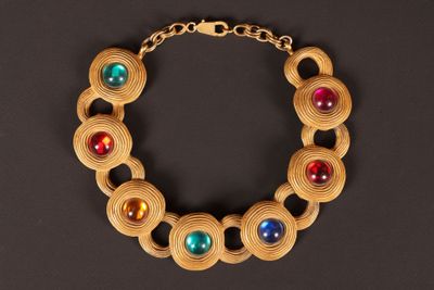 un gros plan d'un bracelet en bois posé sur une surface noire
