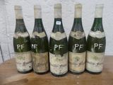 six bouteilles de vin sont alignées sur une table en bois