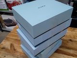 trois boîtes bleues empilées les unes sur les autres sur une table en bois