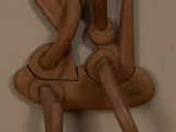 une sculpture en bois représentant un homme et une femme assis sur une chaise
