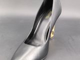 a photo of a pair of silver shoes on a grey surface