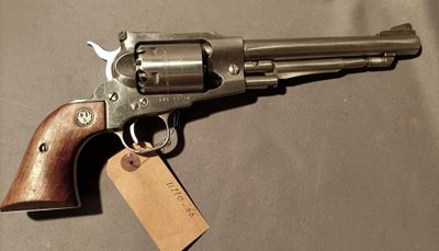 an old revolver with a tag attached to it sitting on a table