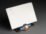 a silver plate with a blue pen on it