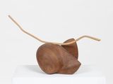 wooden sculpture of a mouse on top of a white pedestal
