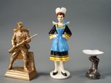 trois figurines représentant des personnes debout les unes à côté des autres