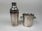 un shaker et un seau à glace plaqués argent sur fond blanc